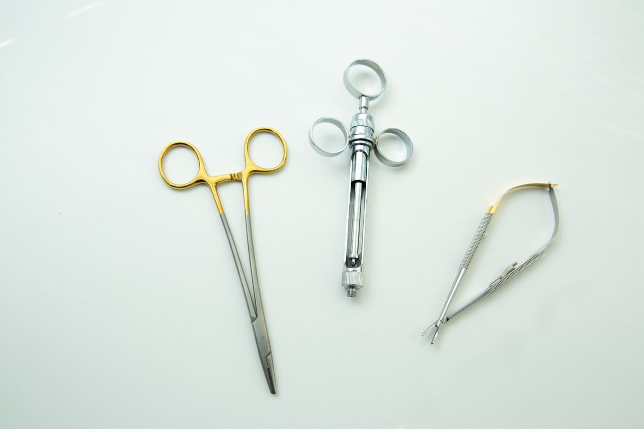 Close-up of surgical instruments on a clean white surface, highlighting precision tools.